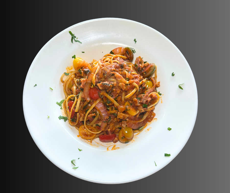 A plate of Linguine alla Puttanesca topped with a rich tomato-based sauce, featuring cherry tomatoes, olives, onions, garlic, and fresh herbs, served on a white dish and garnished with parsley.